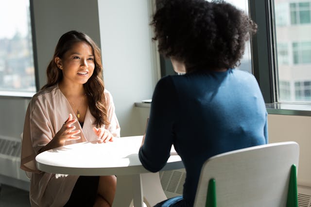 two people talking over table